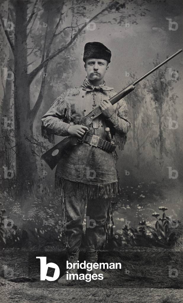 Young Theodore Roosevelt dressed in deer skins posing with a rifle in an 1885 studio portrait. In 1884 he wrote articles about frontier life for Eastern magazines and in 1886 he ran for Mayor as the 'The Cowboy of the Dakotas ' coming in third