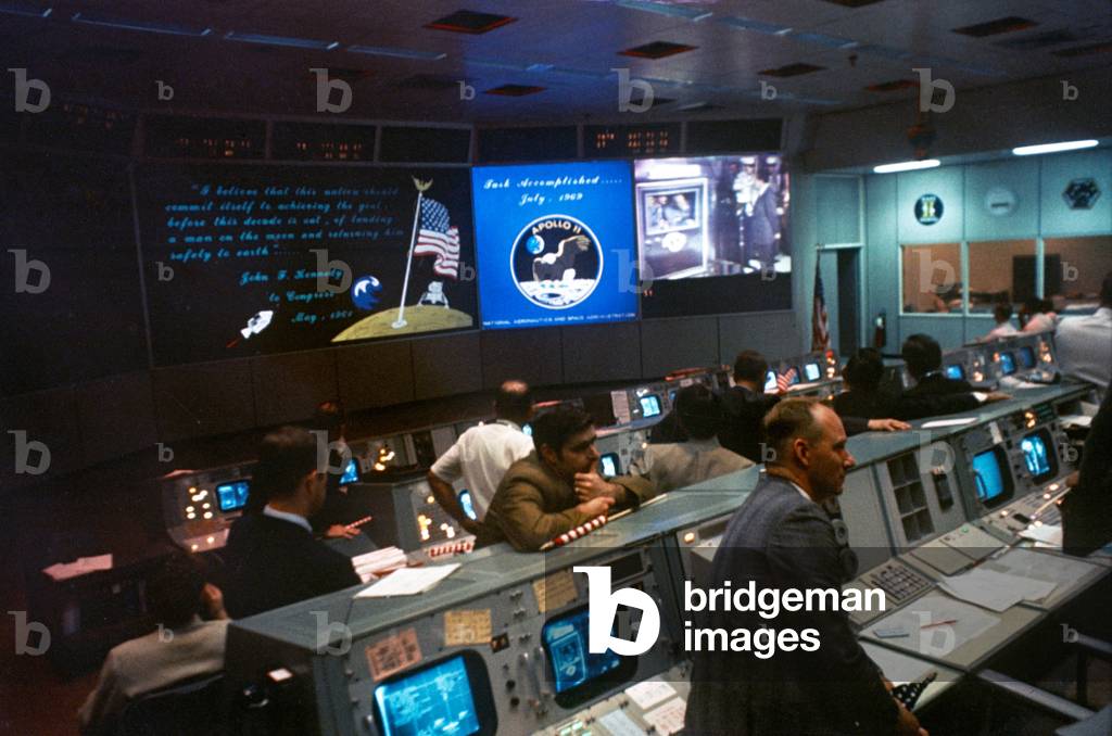 NASA Mission Control during Apollo 11 moon mission. Monitors show President Richard Nixon greeting the astronauts aboard the USS Hornet. July 24, 1969