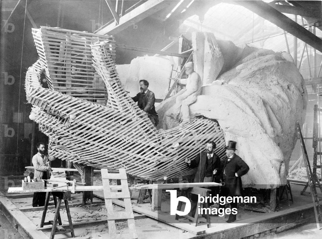 Frederic-Auguste Bartholdi (1834-1904), the French creator of the Statue of Liberty, explains the inner construction of the Hand section of the statue to a visitor