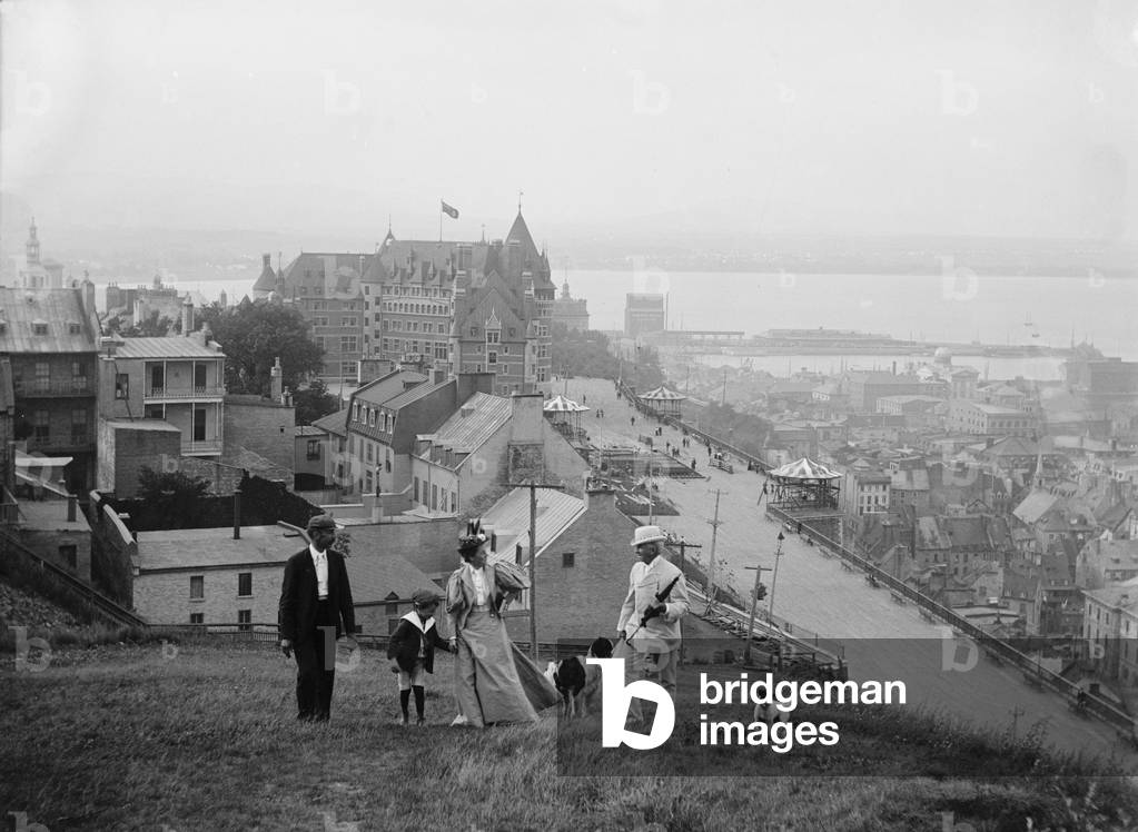 A family walks on the heights of Quebec City. Le Château Frontenac in the background is still the premier Quebec City landmark. 1910's