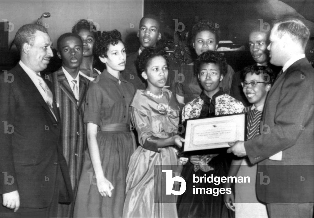 Chat Patterson presents Americanism award to nine African American students who integrated Central High School in the fall of 1957. From left, William R. Ming, Terrence Roberts, Melba Patillo, Carlotta Walls, Jefferson Thomas, Gloria Ray, Minnie Brown, Elizabeth Eckford, Thelma Mothershed, Ernest Green, and Chat Patterson. Little Rock, Arkansas, 1/27/58.