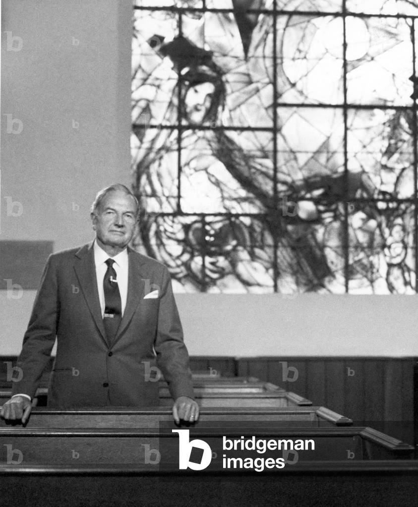 David Rockefeller in front of the stained glass window « Le bon Samaritain » (1963-64) in the Union Church, Pocantico Hills, NY, 1985 (b/w photo)