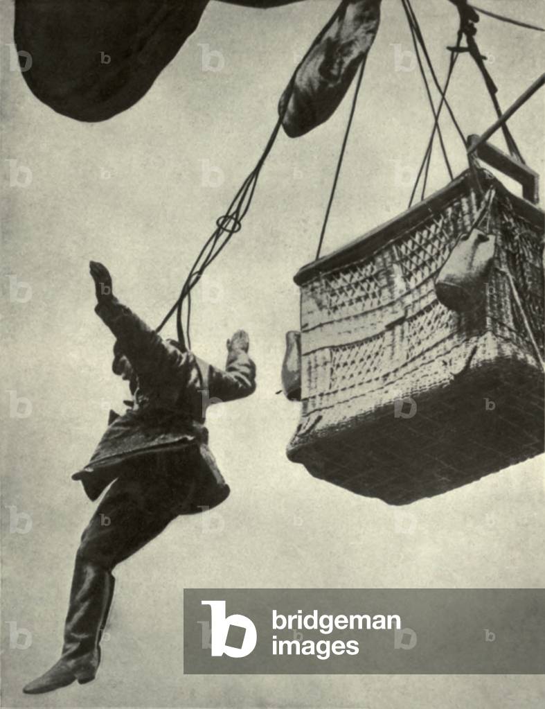 German WW1 observer jumping from burning balloon harnessed to a parachute. 1916-18. The parachute was attached to the basket's side so as to detach. To this, the observer was buckled by straps and cord. Photo was taken by a nearby aviator