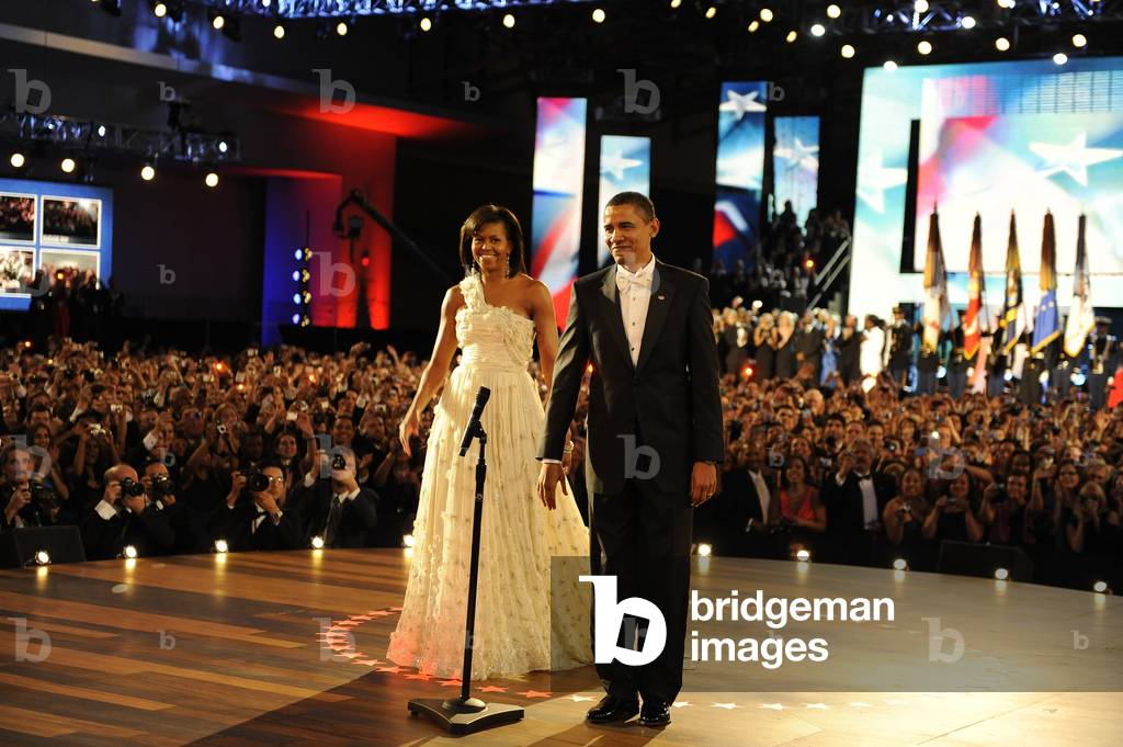 President and Michelle Obama are cheered as they arrive at the Neighborhood Ball. Jan. 20 2009. Michelle is wearing an ivory chiffon one shoulder dress by Jason Wu. (BSWH_2011_8_186)