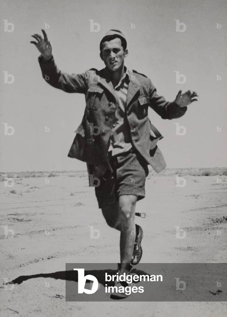Surrendering Italian infantryman running towards a British patrol in Libya. c. 1940-42