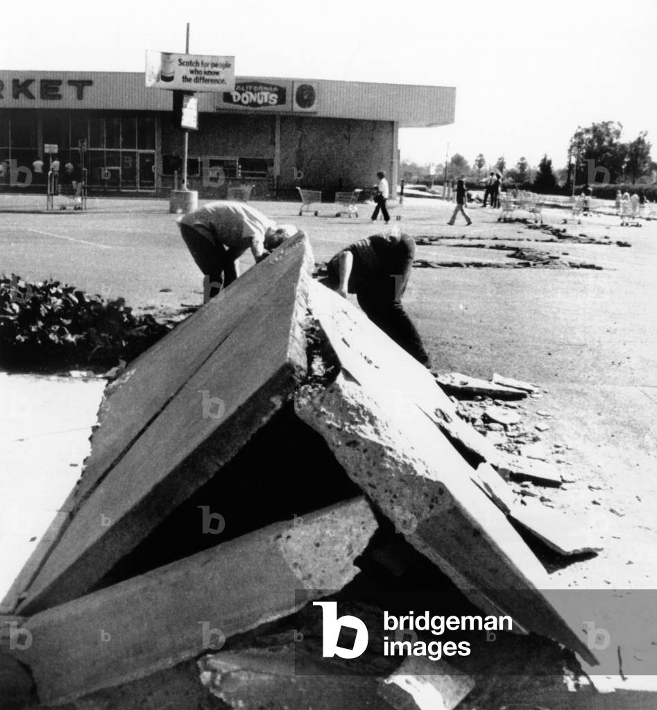 1971 San Fernando Earthquake. Two boys look under a section of buckled concrete in downtown Sylmar, California. Feb. 9, 1971