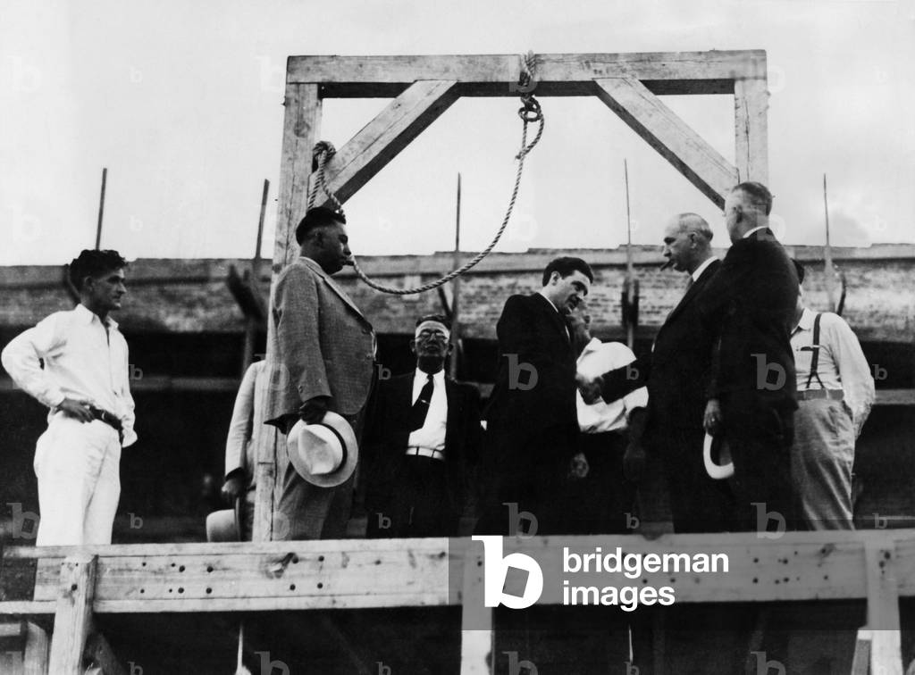 Arthur Gooch shakes hands with Deputy Warden Jess Dunn of the McAlester, Oklahoma penitentiary. Gooch was hanged for kidnapping minutes later, 1936.