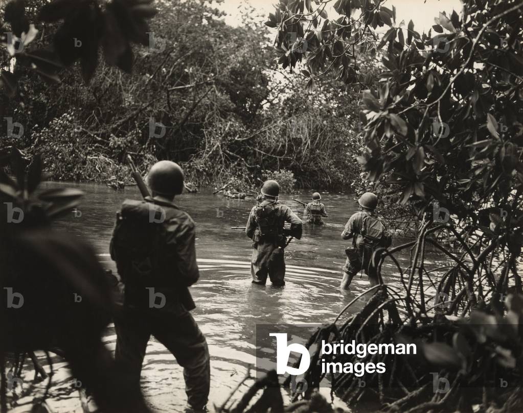 American soldiers wading through water in on an island in the New Georgia Group of the Solomon Islands as part of General Douglass MacArthur's, Operation Cartwheel, against the Japanese base at Rabaul, Papua New Guinea. 1943