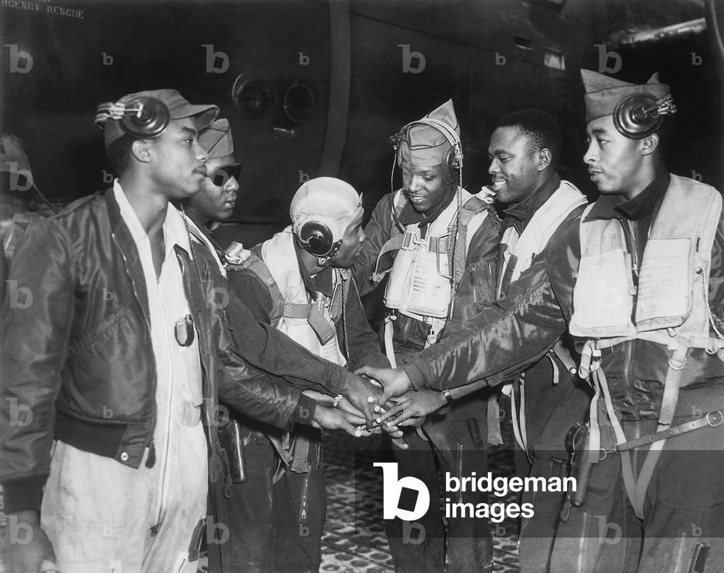 Six African American Air Force gunners join hands. They are part of 17th Bomb Wing night interdiction teams in Korea. Air interdiction attacked ground targets not close to friendly ground forces. Korean War, 1950-53