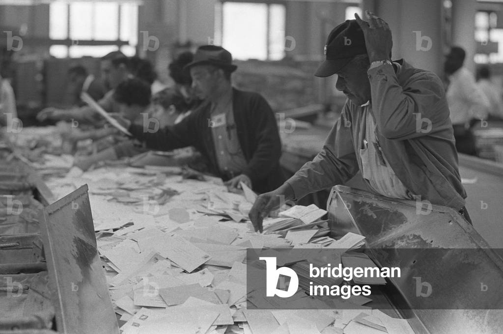 African American postal employees sorting mail beside white workers. March 1, 1966, Washington, D.C. vicinity