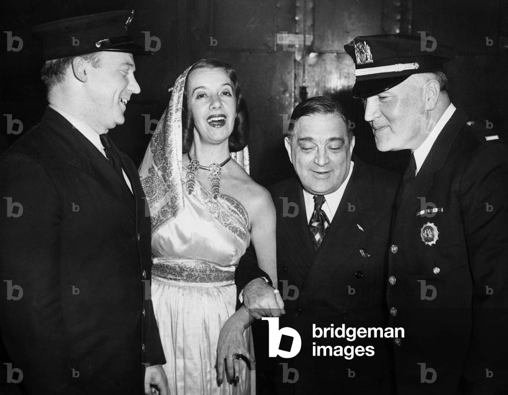 Fiorello LaGuardia, with fireman John Cocoman, opera star Lily Pons, and Lt. Thomas J. Sheehan of the Juvenile Aid Bureau at the 4th annual benefit for the Police Athletic League at Madison Square Garden, NYC 12/11/45