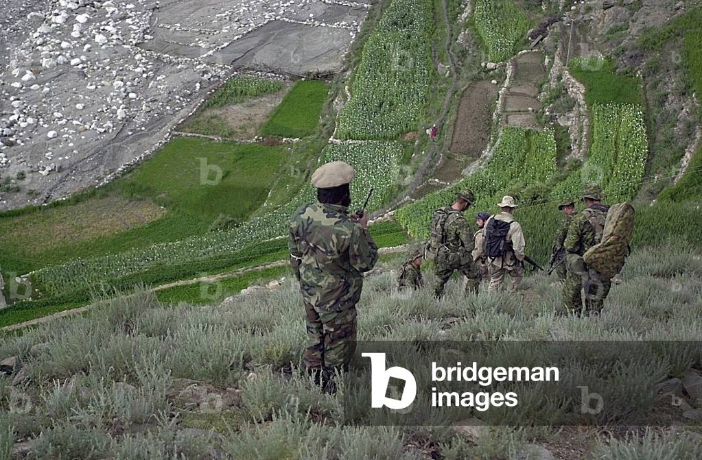 Coalition soldiers from U.S. Canada and Afghanistan looking for Osama Bin Laden Taliban and Al Qaeda forces near the village of Markhanai in the Tora Bora region of Afghanistan. May 7 2002., Photo by:Everett Collection