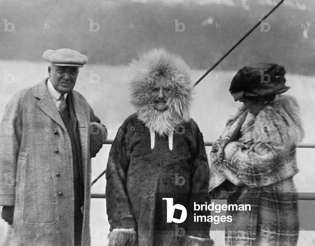 Governor Bone of the Alaska Territory, stands between President and Mrs. Harding. In a fur-lined parka, Gov. Scott Bone joined Warren Harding's tour as they sailed on the USS Henderson to Seward in July 1923. Florence Harding appears to be quite chilled
