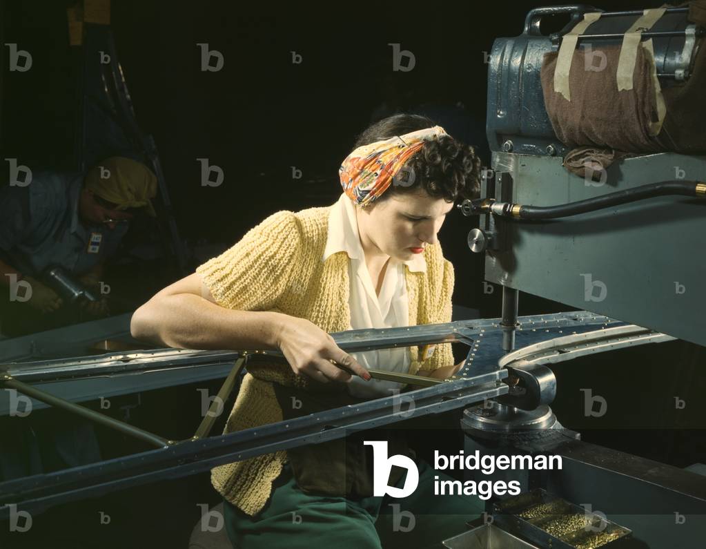 Woman operating a riveting machine on wing of B-17F heavy bombers during World War 2. Douglas Aircraft Company, Long Beach, California, Oct. 1942