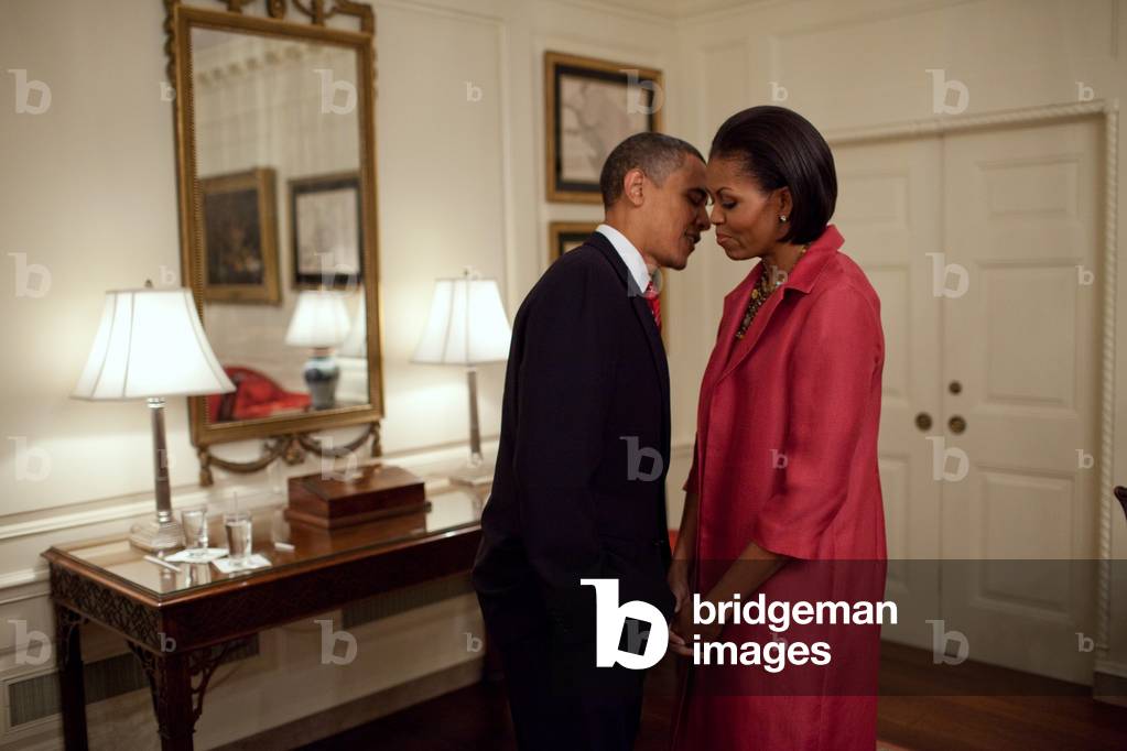 President and Michelle Obama wait to welcome President Felipe Calder n of Mexico to the White House May 19 2010. Michelle wears a carmine viscose jersey dress with a silk nylon coat from Calvin Klein's Pre-Spring 2009 collection.,
