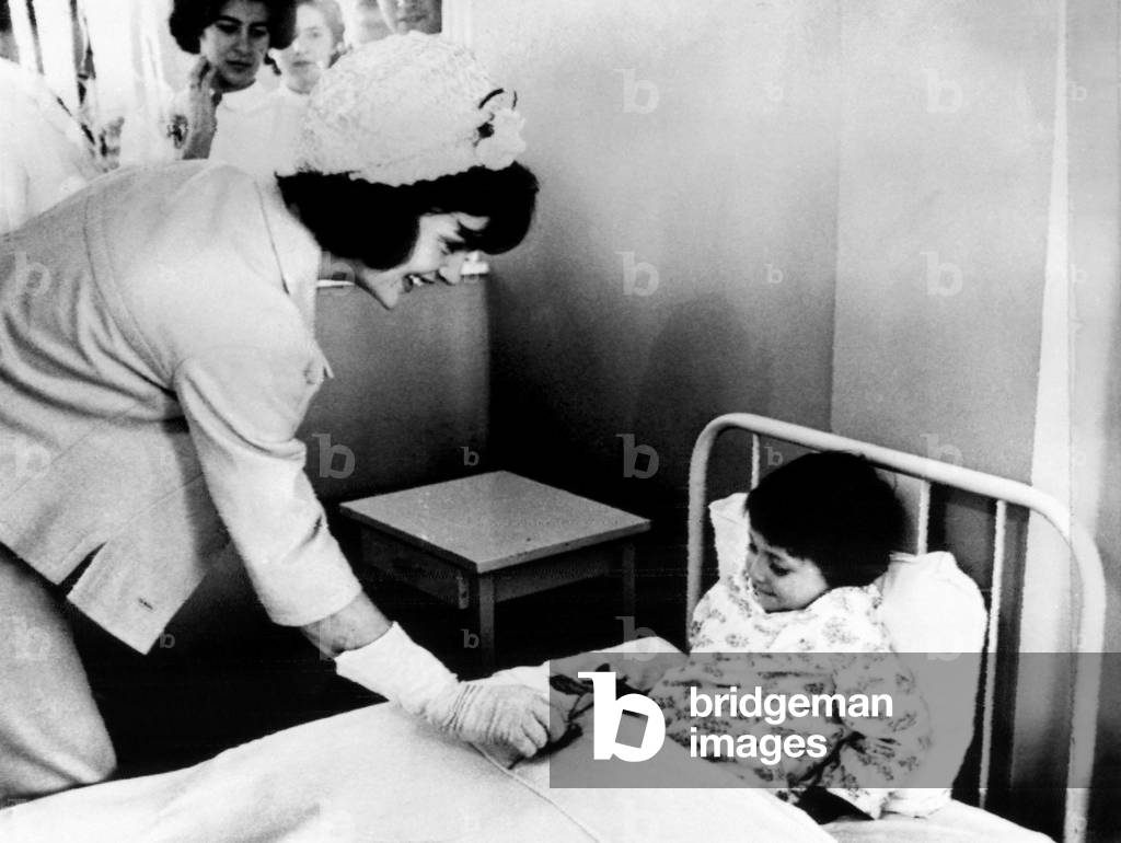 Jacqueline Kennedy (left), presents a patient at the children's hospital with a flower in Bogota, Colombia. December 17, 1961