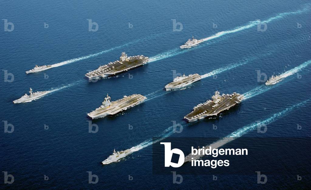 Naval vessels from five nations France Italy Netherland UK and US sail in parade formation. In four descending columns from left to right ITS Maestrale De Grasse USS John C. Stennis Charles de Gaulle Surcouf USS Port Royal HMS Ocean USS John, Photo by:Everett Collection
