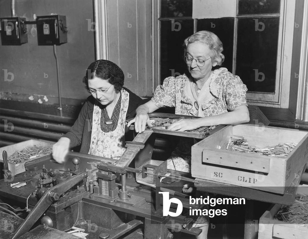 Mothers of the assembly line perform clip spring and bolt assembly at the Frankford Arsenal. Philadelphia, c. 1940-45. World War 2