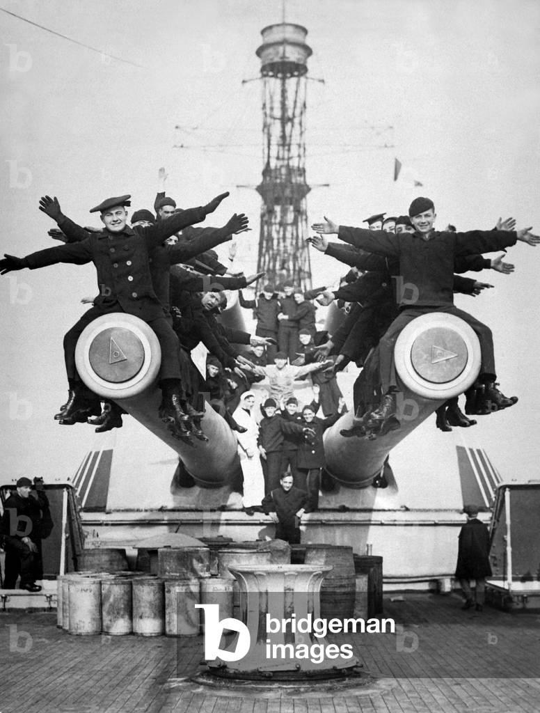 Gobs' and Guns. Aboard the U.S.S. Texas, just back from foreign waters, showing sailors enjoying a little fun on the big guns. World War I. c. 1918