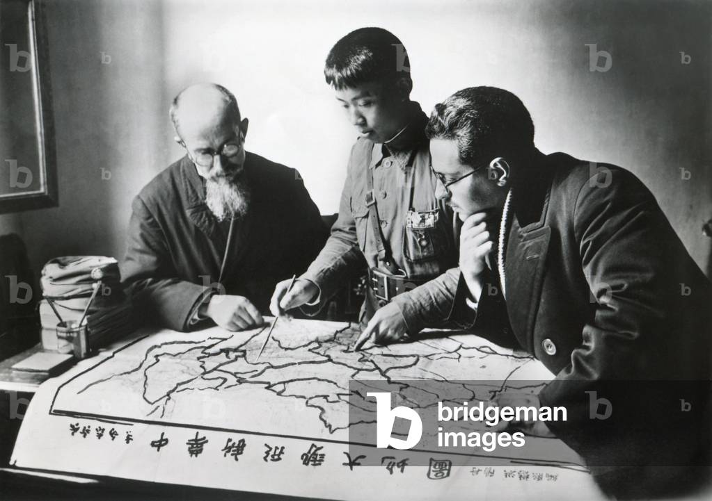 Chinese army officer and two missionaries plot the advance of Communist forces. Christian missions in the provinces of Hunan, Sichuan, Anhui, Jiangxi, Fujian, and Yunnan had fallen under Communist occupation. Nov. 1935.