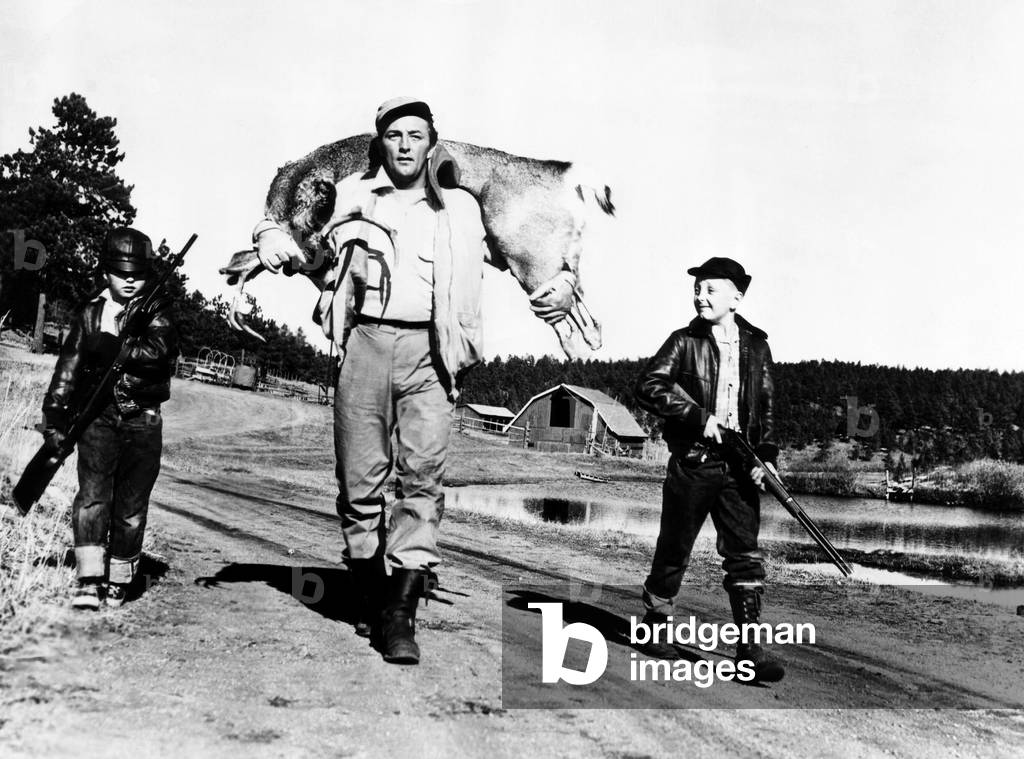 Robert Mitchum (center), and his sons, Chris Mitchum (left), and Jim Mitchum (right), after hunting a six-point buck, c.1952