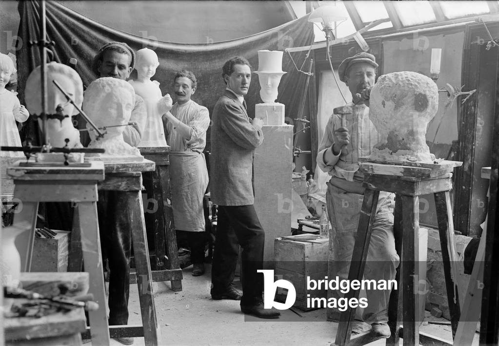 Elie Nadelman (1882-1946), Polish-born American sculptor standing beside his sculpture in an artists studio class. c. 1915