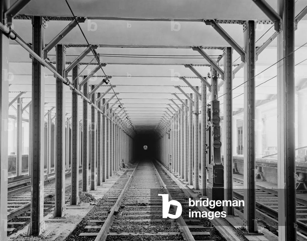 The New York City subway tracks at a station with a dark tunnel in the distance. 1904 LC-D4-17296