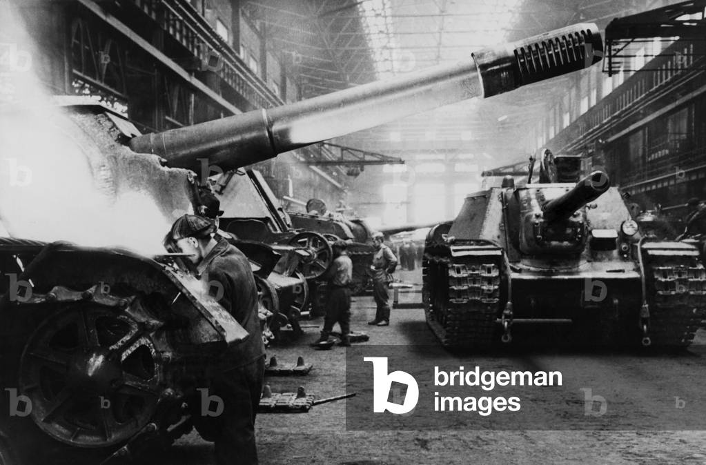 Soviets (Russians) assembling tanks at a Soviet plant in the Urals. The factory maintained day and night schedules during World War 2