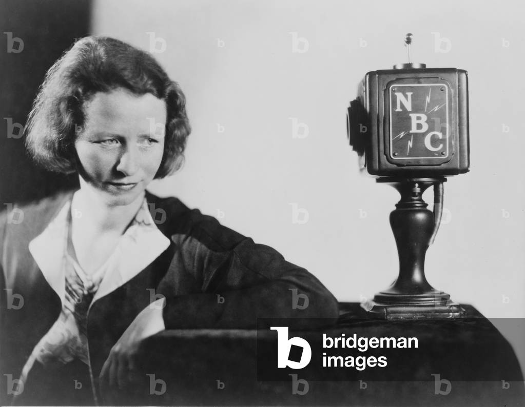 Edna St. Vincent Millay (1892-1950) American poet, seated behind NBC microphone reciting her poetry. 1945