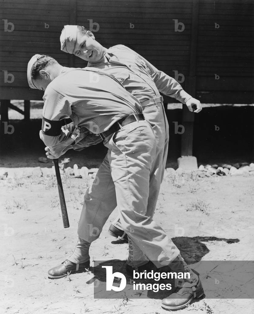 World War II, Private Melvin Kearney, and Military Police Private Elliott Schneiderman (front), practicing disarming a club man, c.1942