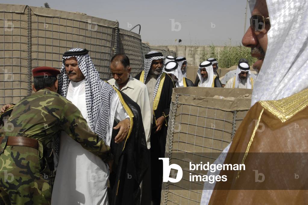 Iraqi soldiers search village leaders prior to meeting in the southern sector of the city of Baghdad Iraq on July 4 2007