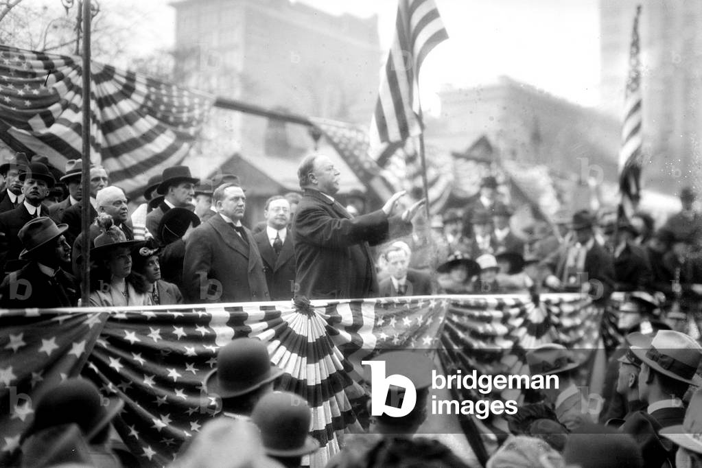 President William Taft (1857-1930) speaking on a flag draped podium in 1909