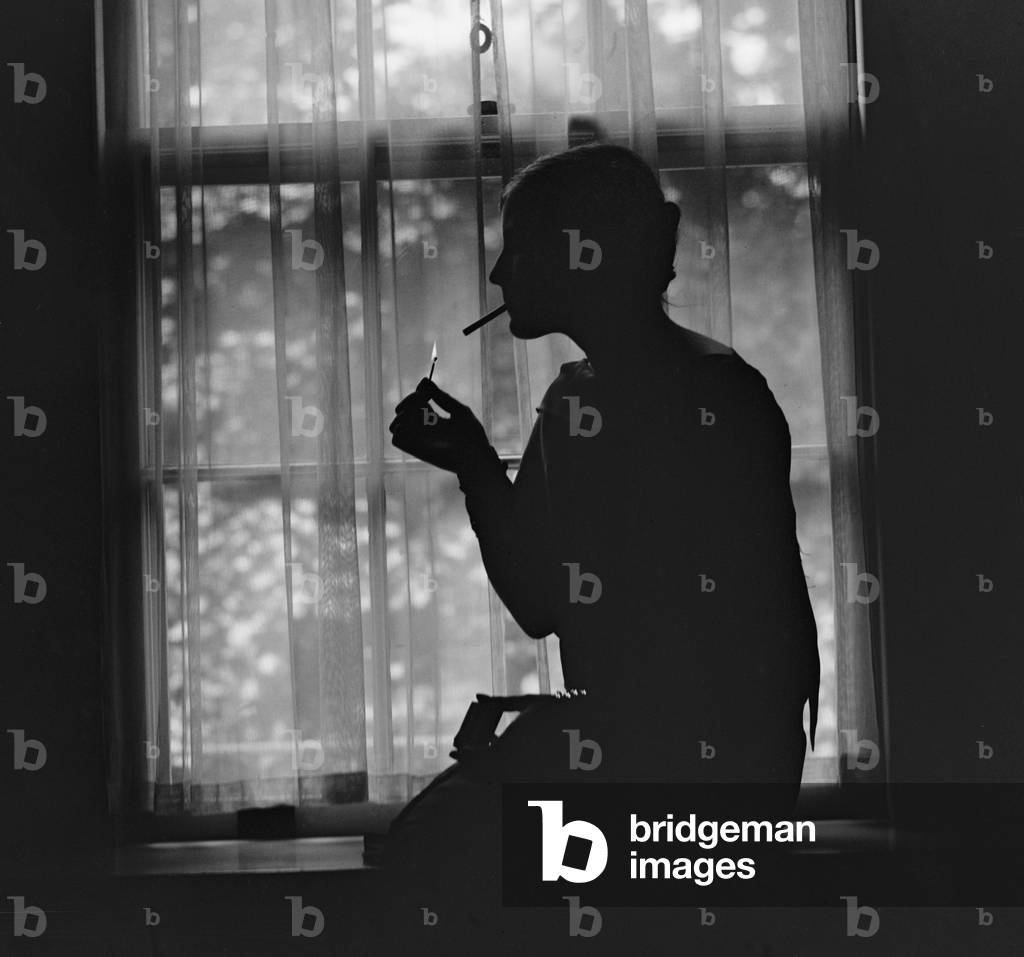 Silhouette of a stylish women smoking in 1926. During the 1920s, many women took up cigarette smoking, which was a symbol of women's independence before the health hazards were widely acknowledged