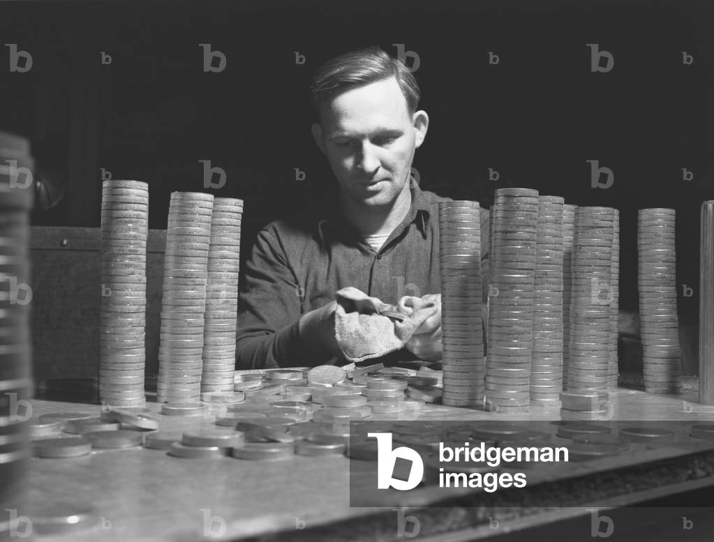 Circular blanks of copper and crass inspected for flaws in metal structure before they become shell casings for the U.S. in World War II. Chase Copper and Brass Company, Euclid, Ohio, 1942