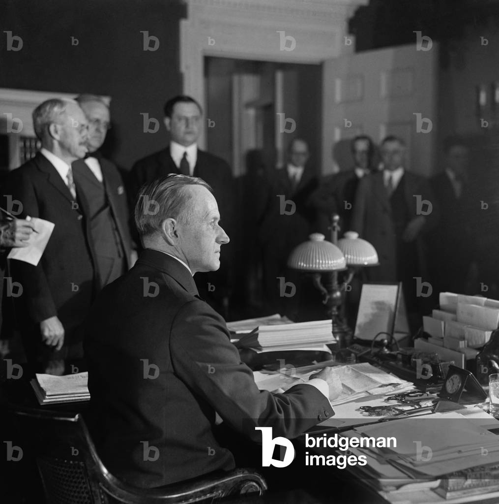 President Calvin Coolidge signing the United States Revenue Act of 1926. It reduced inheritance and personal income taxes, eliminated the gift tax, and ended public access to Federal Income Tax returns