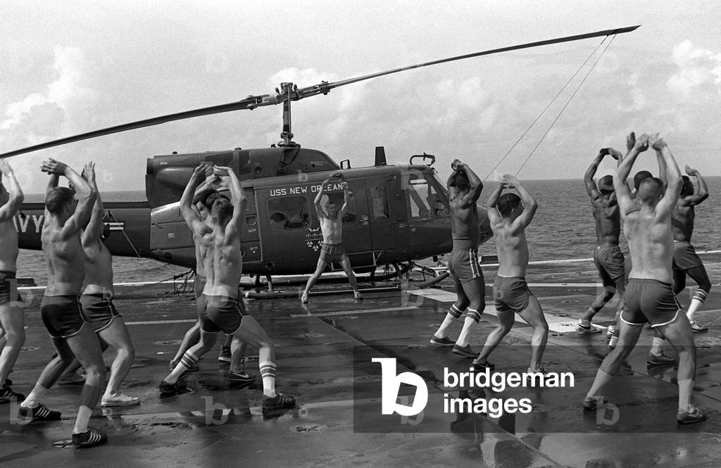 Marines doing jumping jacks on the deck of the amphibious assault ship USS NEW ORLEANS. Aug. 1 1982