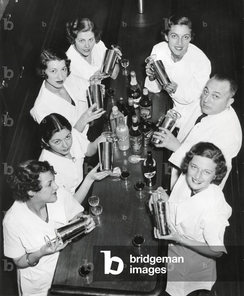 Smiling men and women with cocktail shakers at Prohibition's end. Dec. 1933