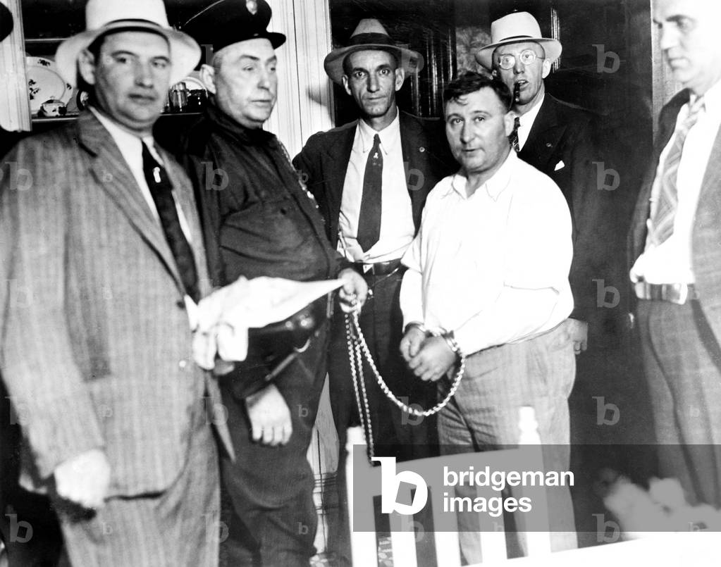 Harry F.Powers (R), the murderer, manacled to Sheriff Grimm,(L), in custody in West Virginia, August 31, 1931