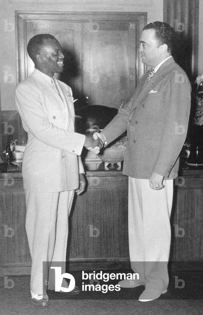 FBI Director J. Edgar Hoover shakes hands with actor/dancer Bill 'Bojangles' Robinson. Aug. 19, 1937