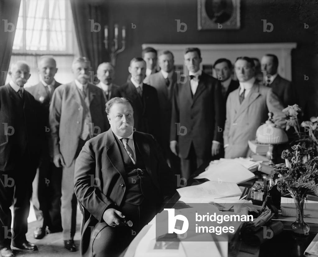 President William H. Taft at his desk in the Oval Office he had built centered in the south side of the West Wing of the White House. The room had simple Georgian Revival details and green walls. c. 1910