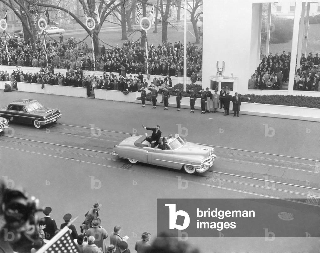 Vice President Richard Nixon standing in an open car in the inaugural parade. Jan. 20, 1953. Pat Nixon's white glove waves to the crowd.