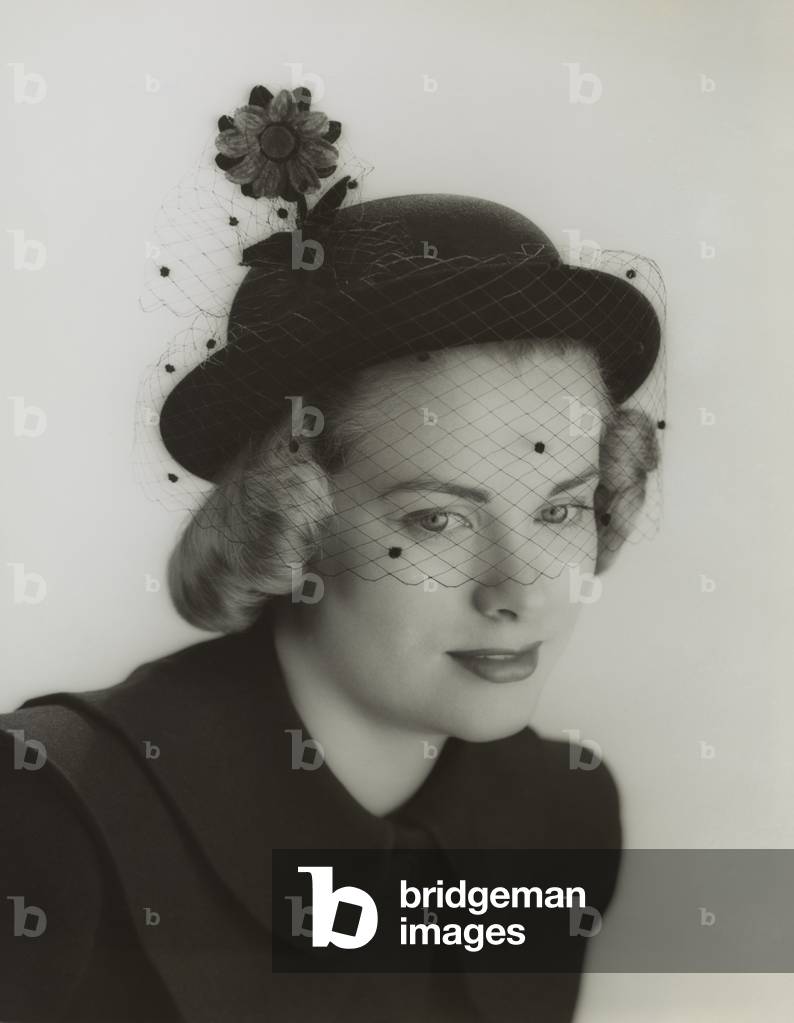 Grace Kelly modeling a veiled hat at age 19 in 1949. She was studying at the American Academy of Dramatic Arts in New York (b/w photo)