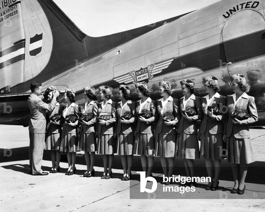 Don F. Magarrell gives new United Airlines stewardesses their wings. The national defense business caused a growth in air traffic, 1941