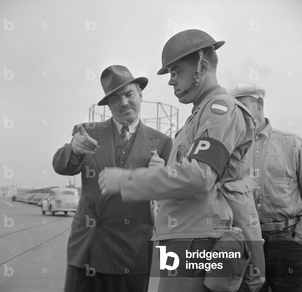 Day after Pearl Harbor attack in San Francisco. Military police checks IDs at transport dock. Dec. 8, 1941