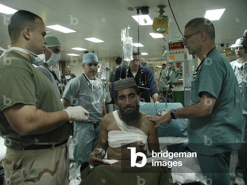 Medical personnel of USS Bataan treat wounded Pashtun soldier from Afghanistan Dec. 6 2001., Photo by:Everett Collection