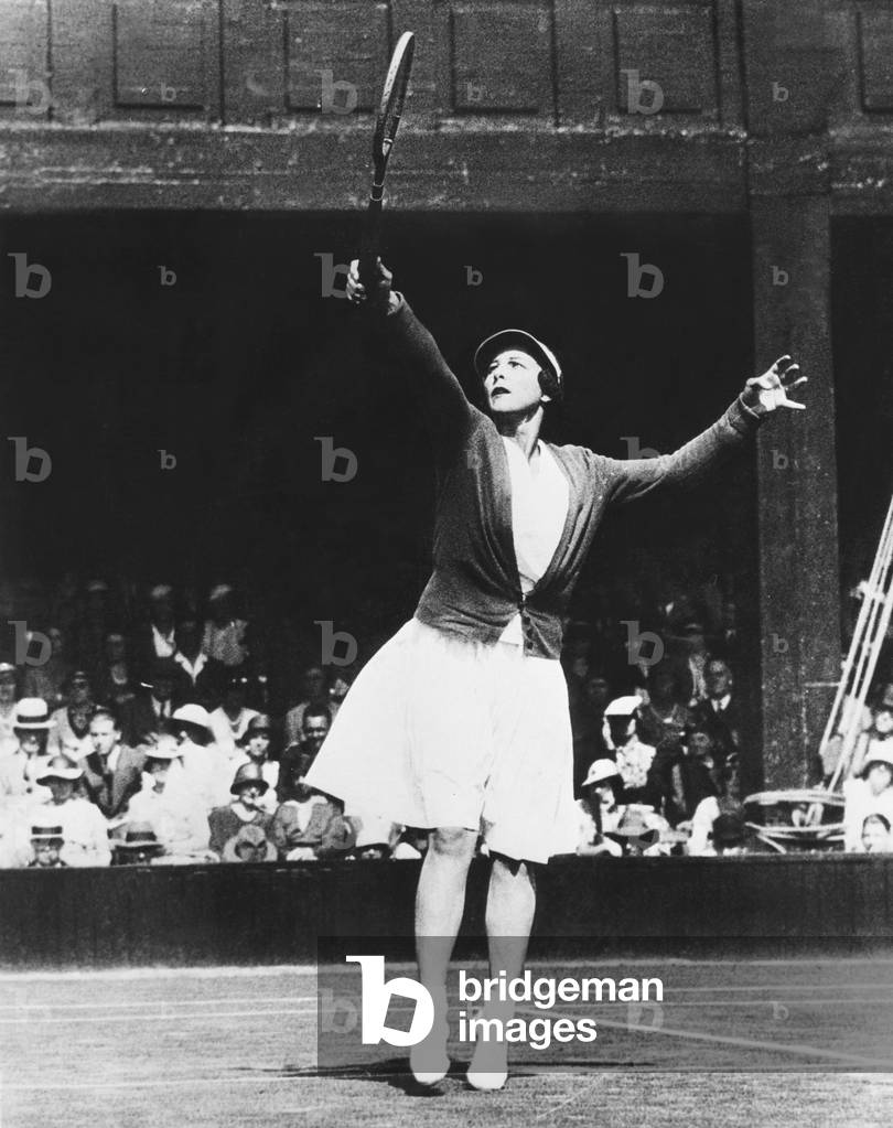 Helen Wills Moody returning a high one during her match with Mrs. J.P. Macready of England. July 4, 1933. Wills Moody won the match , 6  0, 6 0, in the first round of the Women's Singles Championships at Wimbledon England