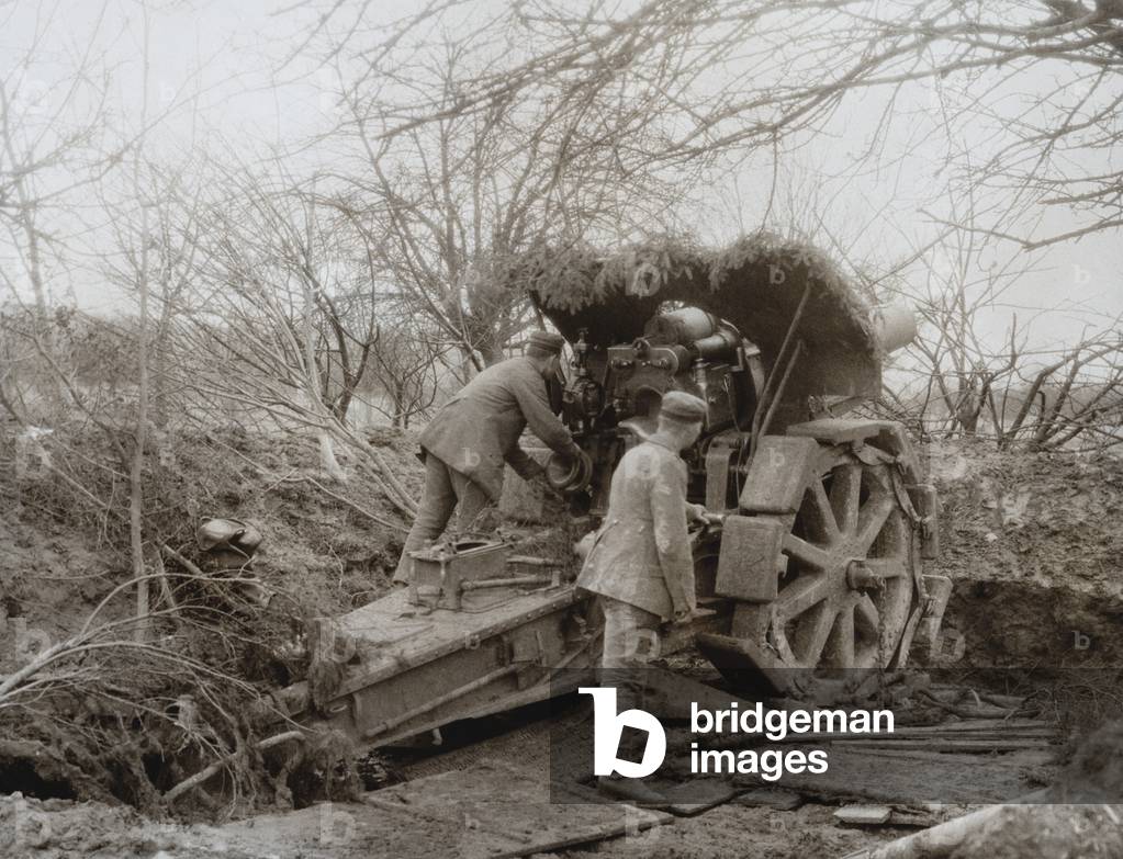 German Soldiers at a camouflaged Howitzer during World War 1. 1914-15. Artillery was the major weapon of WW1, accounting for 60% of casualties