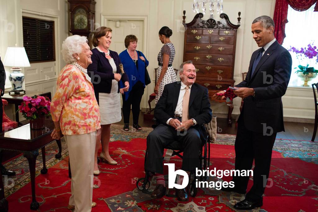 George H. W. and Barbara Bush present President Barack Obama with a pair of colorful socks. July 15, 2013 (photo)
