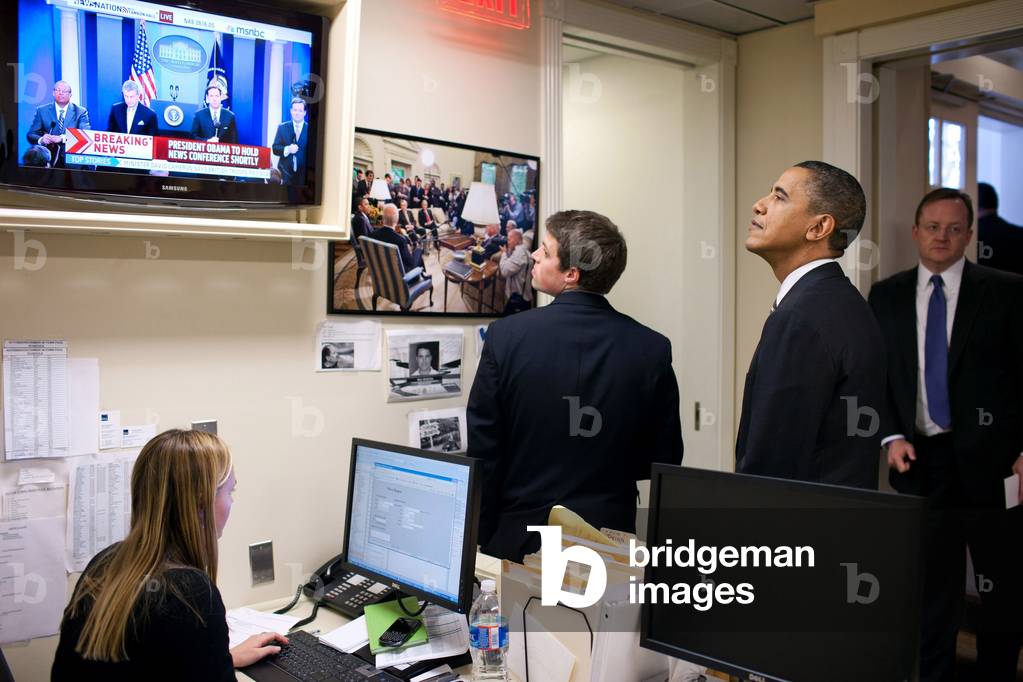 President Barack Obama watches MSNBC coverage of his News Conference as he waits in the Lower Press Office of the White House before going to the podium. Dec. 7 2010.,