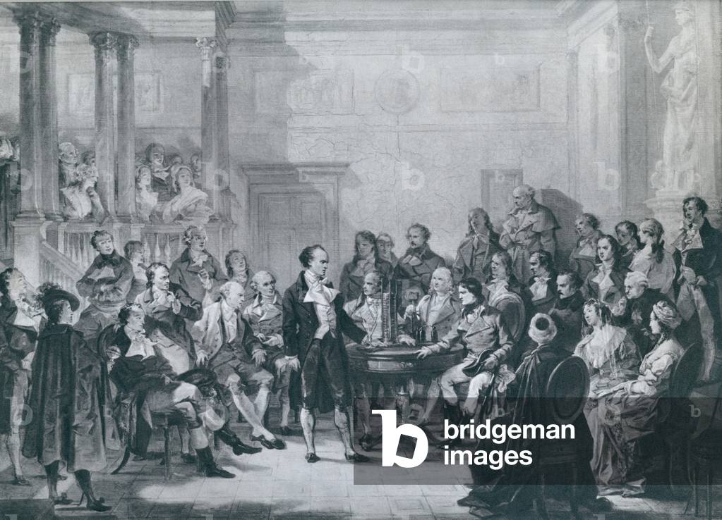 Alessandro Volta (1745-1827), demonstrating his electricity generating apparatus to Napoleon, for which Napoleon made him a count. Volta's device is now called a voltaic pile, an early electric battery, which produced a steady electric current. 1810